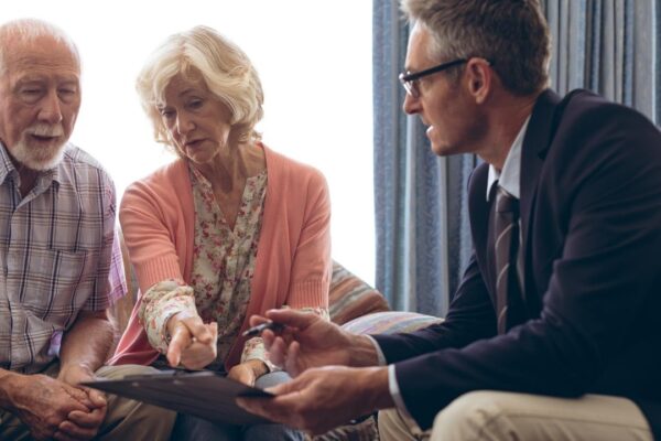 Male physician interacting with senior couple at retirement home