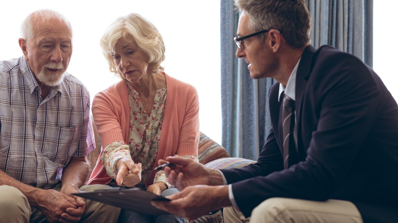 Male physician interacting with senior couple at retirement home