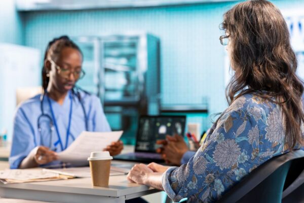 Female nurse and patients reviewing diagnostic results in a medical office