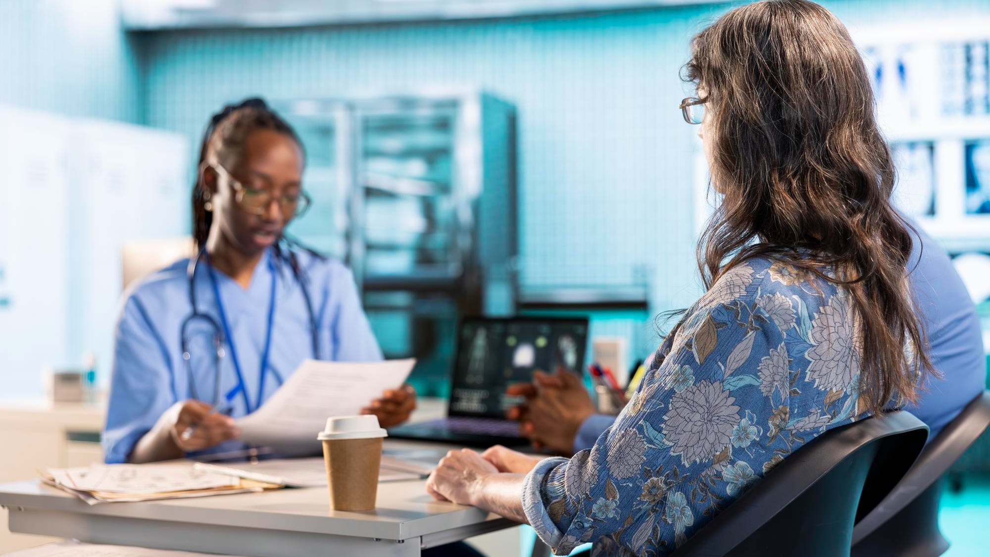 Female nurse and patients reviewing diagnostic results in a medical office