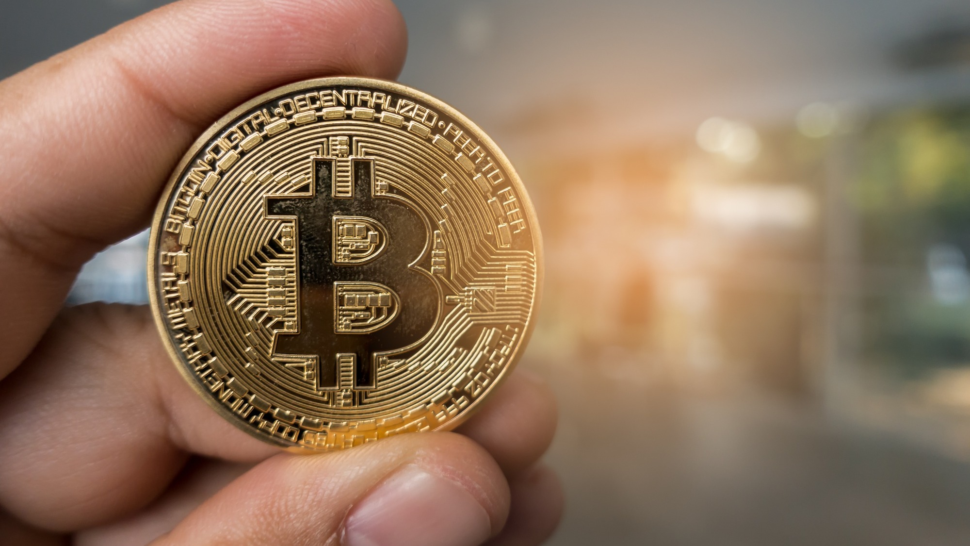 Closeup Golden bitcoin coin in a business office.