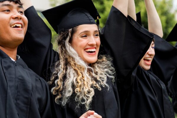 Happy students graduating university, celebrating with diplomas