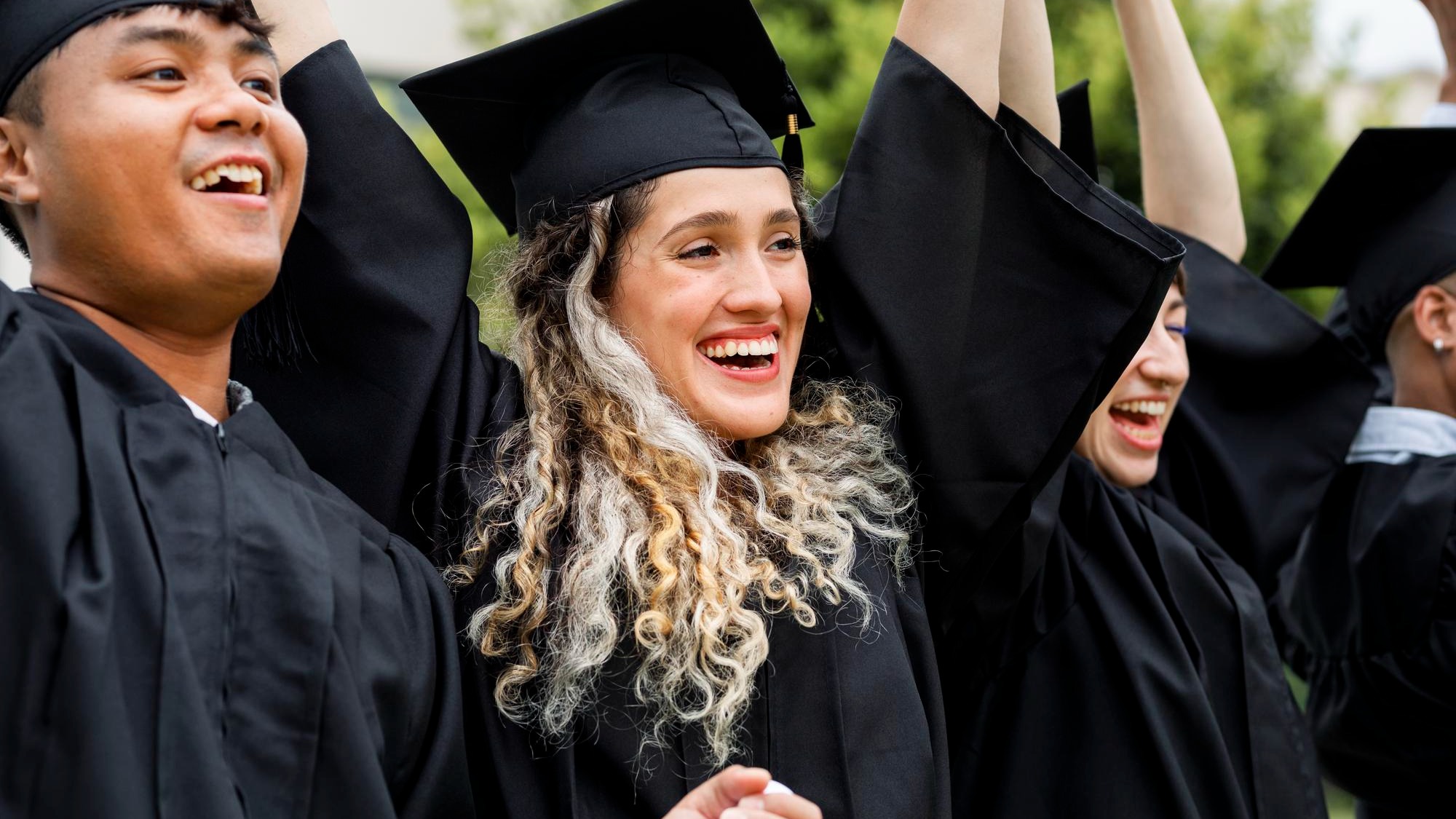 Happy students graduating university, celebrating with diplomas