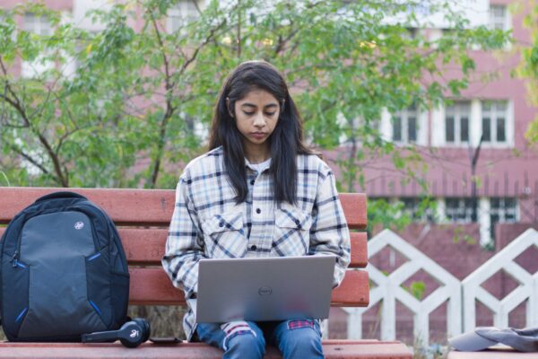 a woman sitting on a bench with a laptop