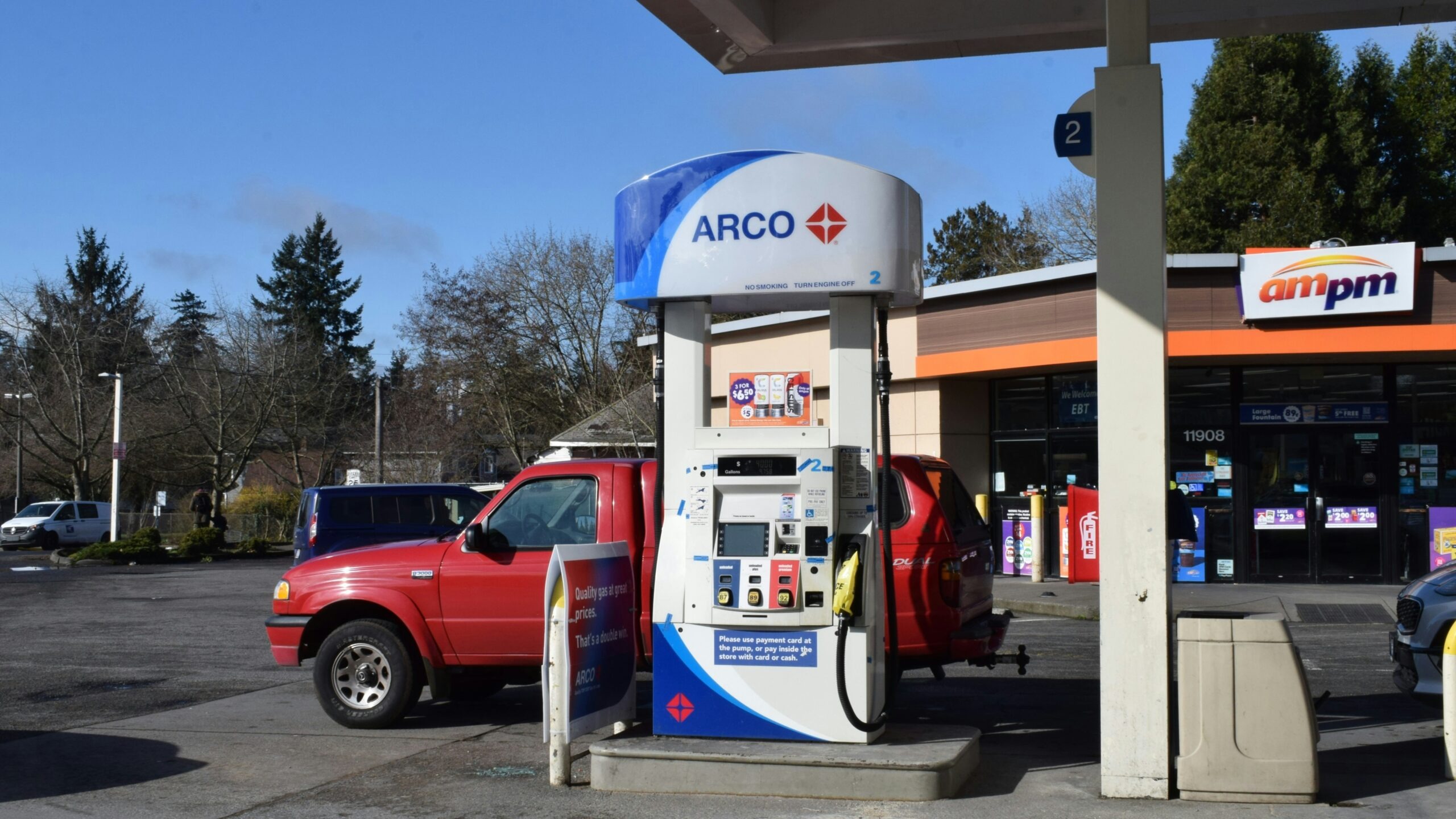 a red truck parked next to a gas station
