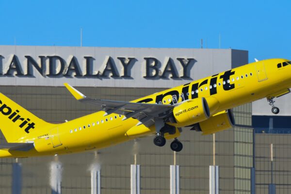 A yellow and black jet airliner taking off from an airport