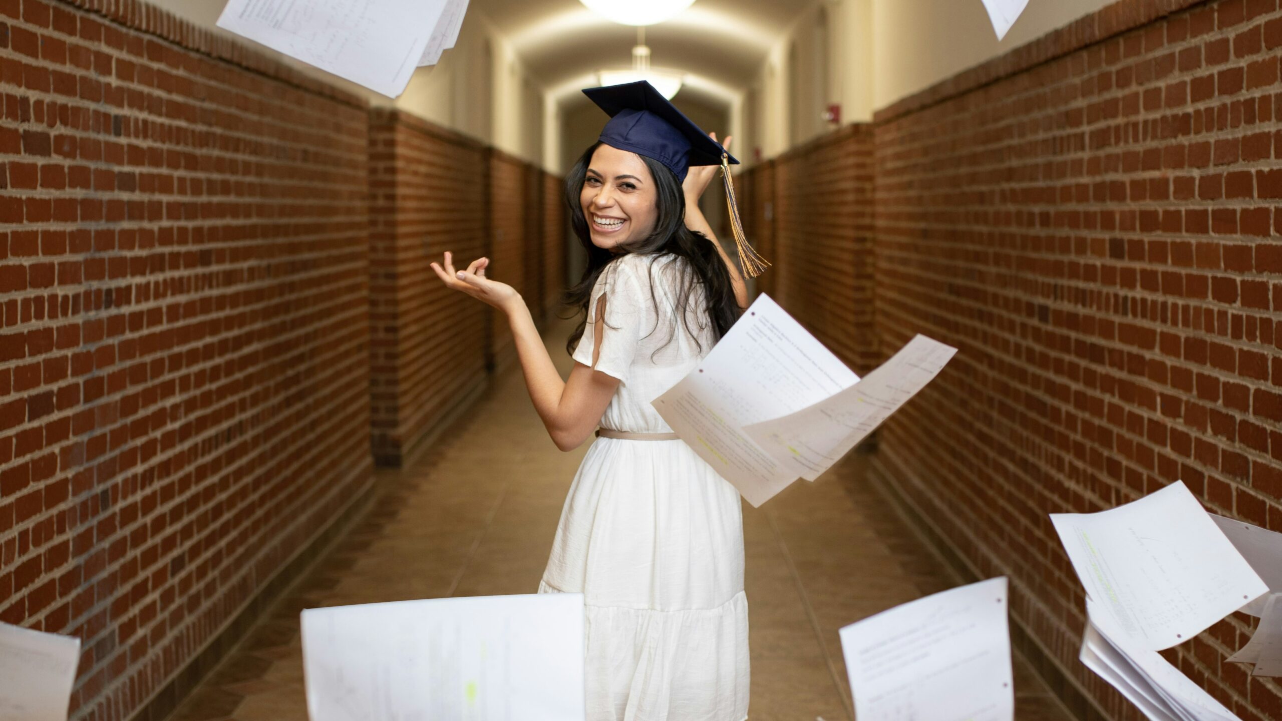 a woman in a graduation cap throwing papers in the air