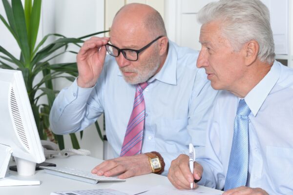 Portrait of two senior Business people working together with computer on the table