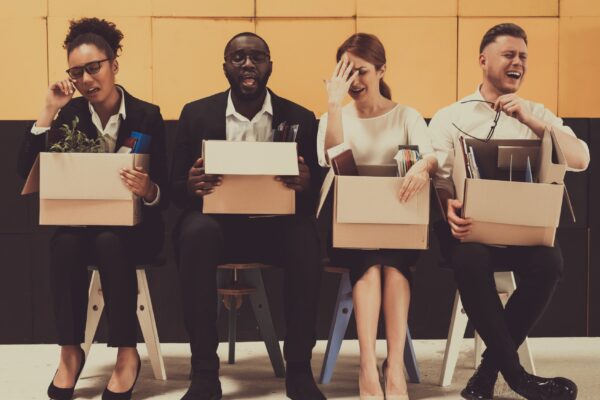 Four Fired Managers Sitting With Office Boxes