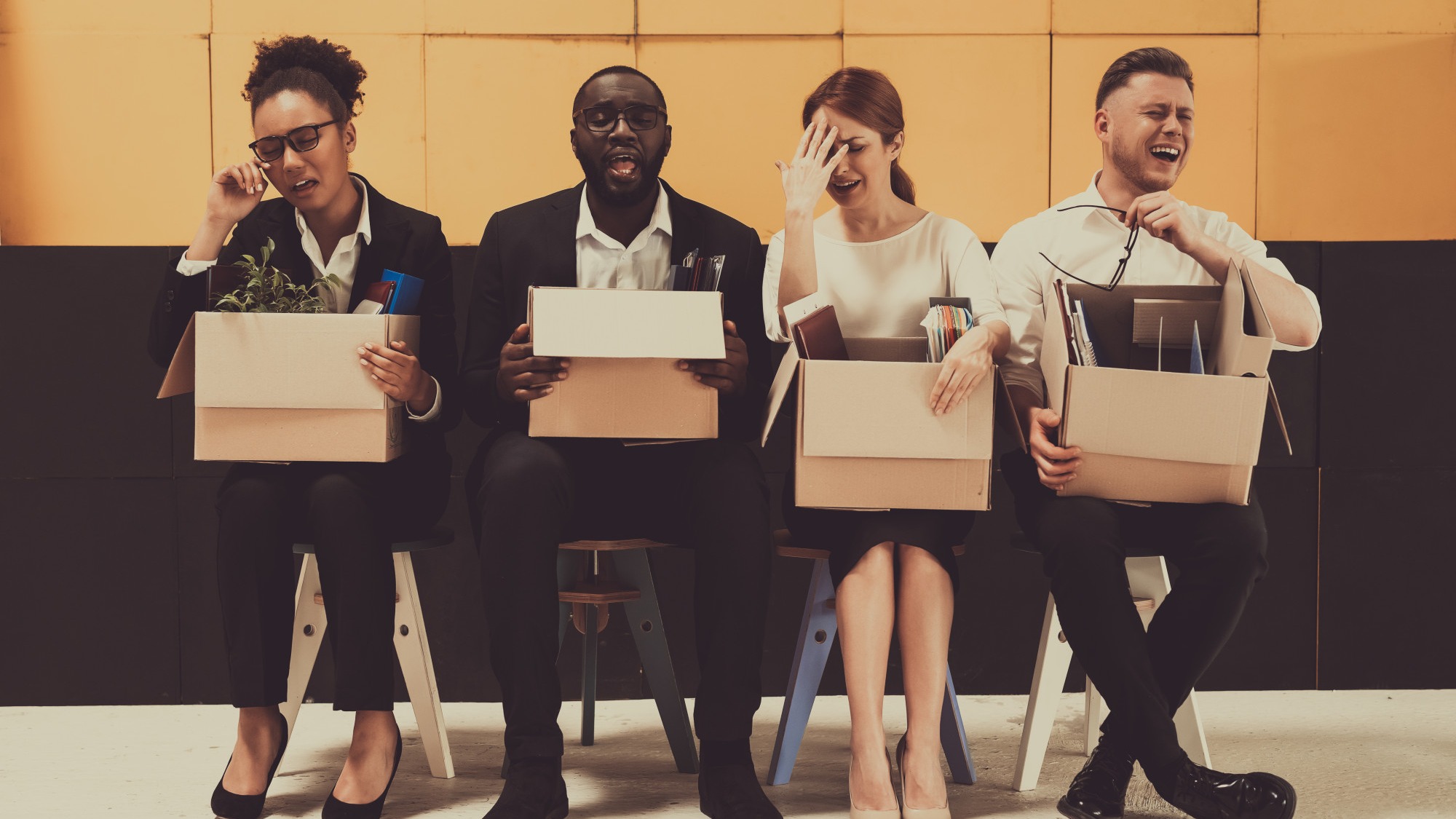 Four Fired Managers Sitting With Office Boxes