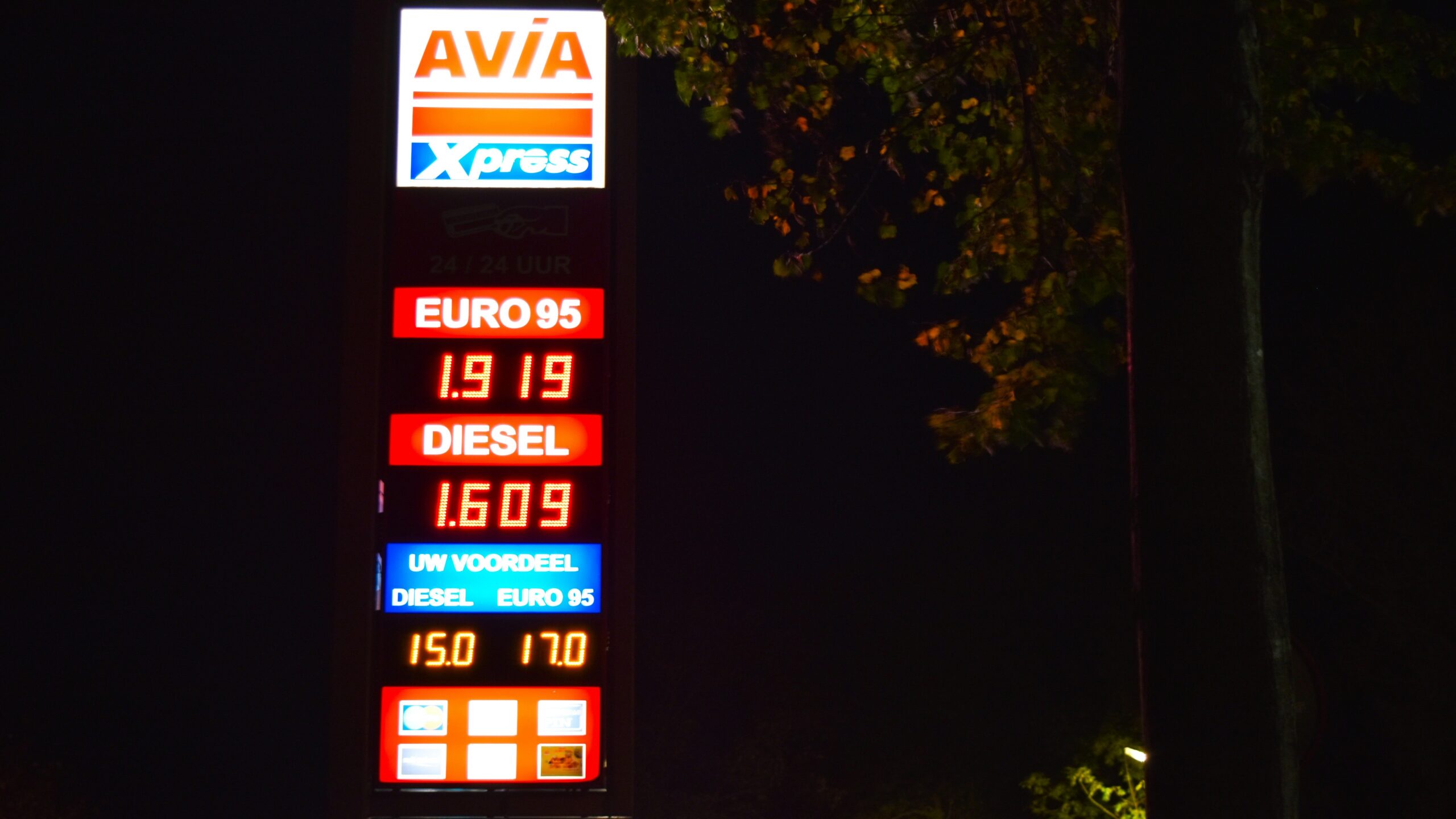 a gas station sign lit up at night