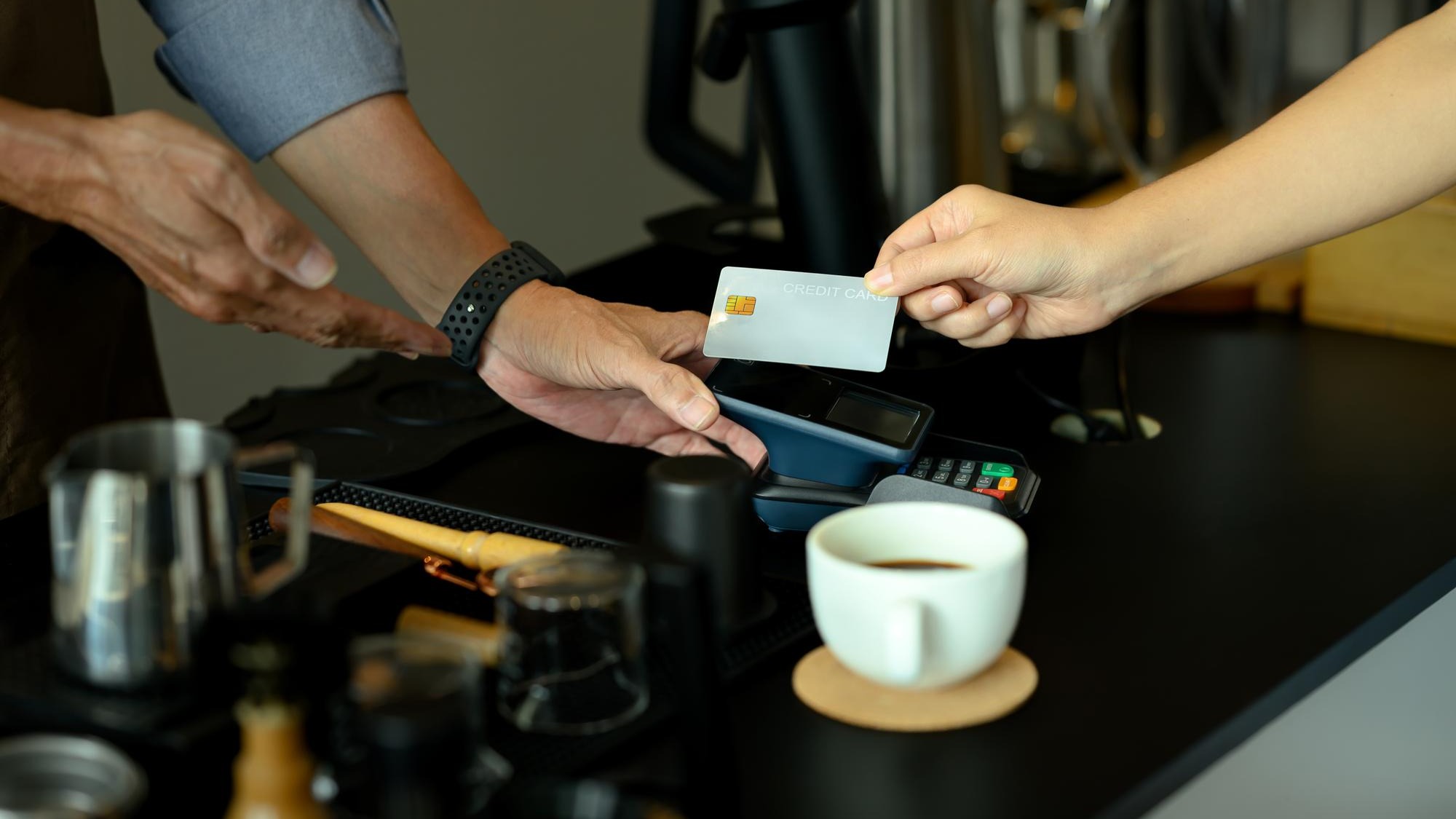 Unrecognizable customer making payment in coffee shop with credit card Financial transaction and technology concept