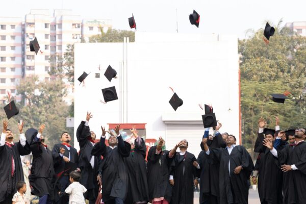 Graduates toss caps in the air celebrating