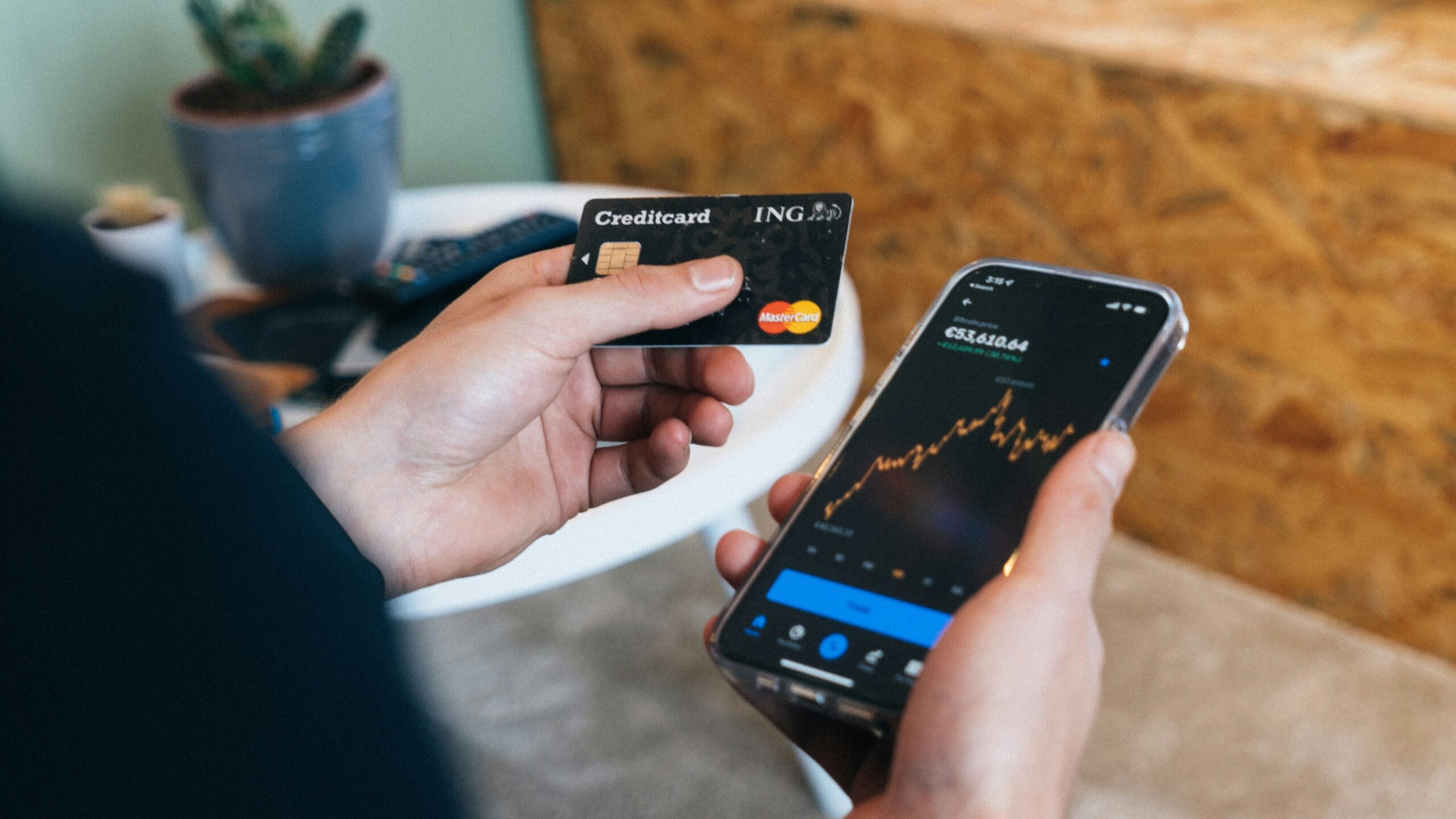 a person holding a smart phone and a credit card