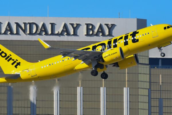 A yellow and black jet airliner taking off from an airport