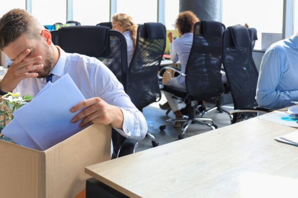 Sad dismissed worker are taking his office supplies with him from office