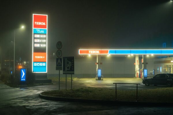 Gas station illuminated at night in the fog.