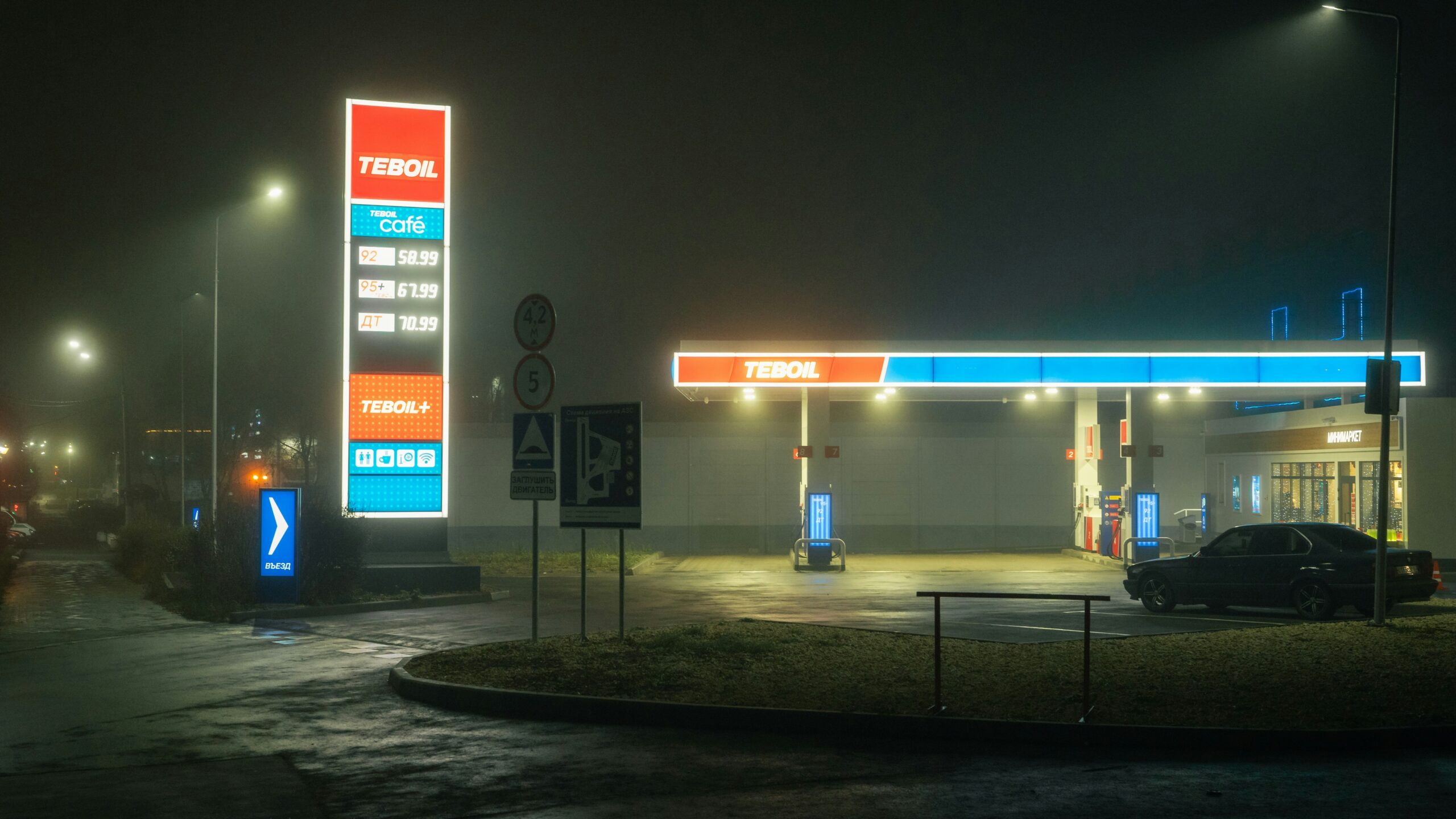 Gas station illuminated at night in the fog.
