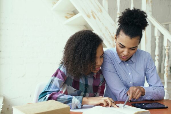 Mother and daughter studying together at a table.