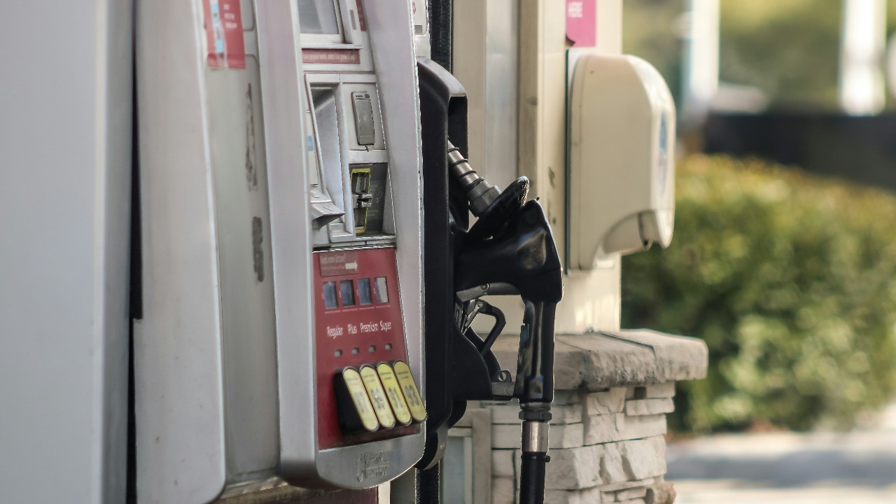 a gas pump next to a brick wall