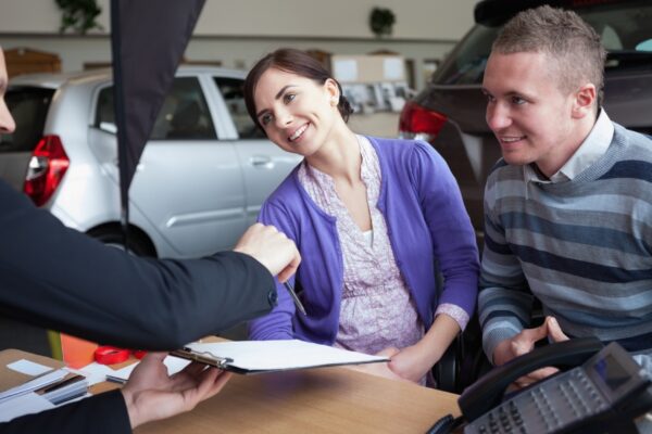 Couple chatting with a car salesman
