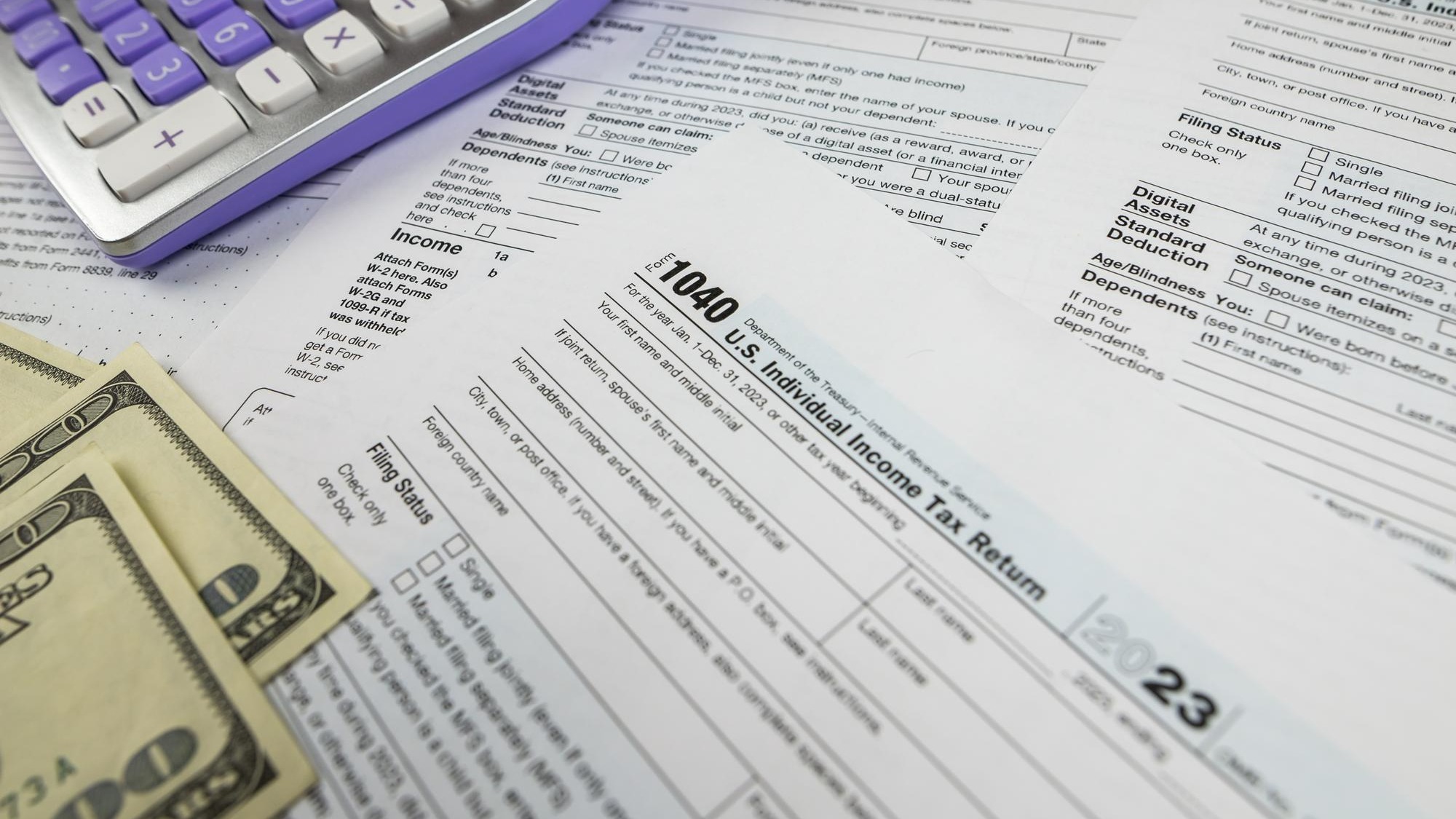 Tax form 1040 with calculator and dollars