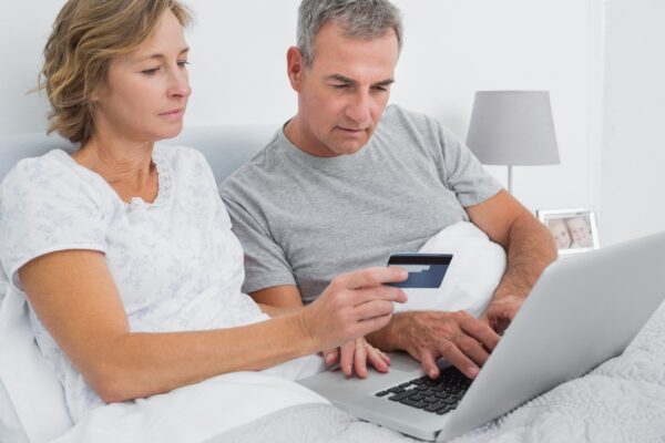 Thoughtful couple using their laptop to buy online