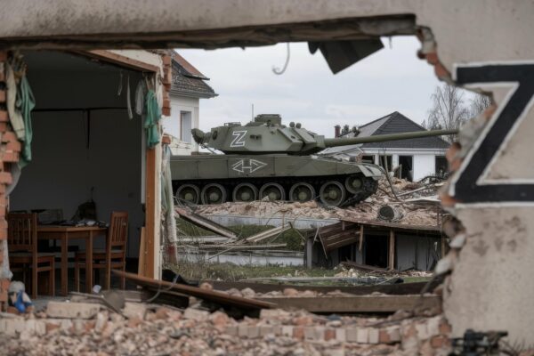 A tank with the z symbol on the background of destroyed houses the concept of confrontation between