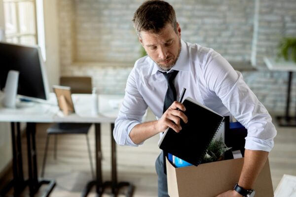 Mid adult businessman getting fired and packing his stuff in the office