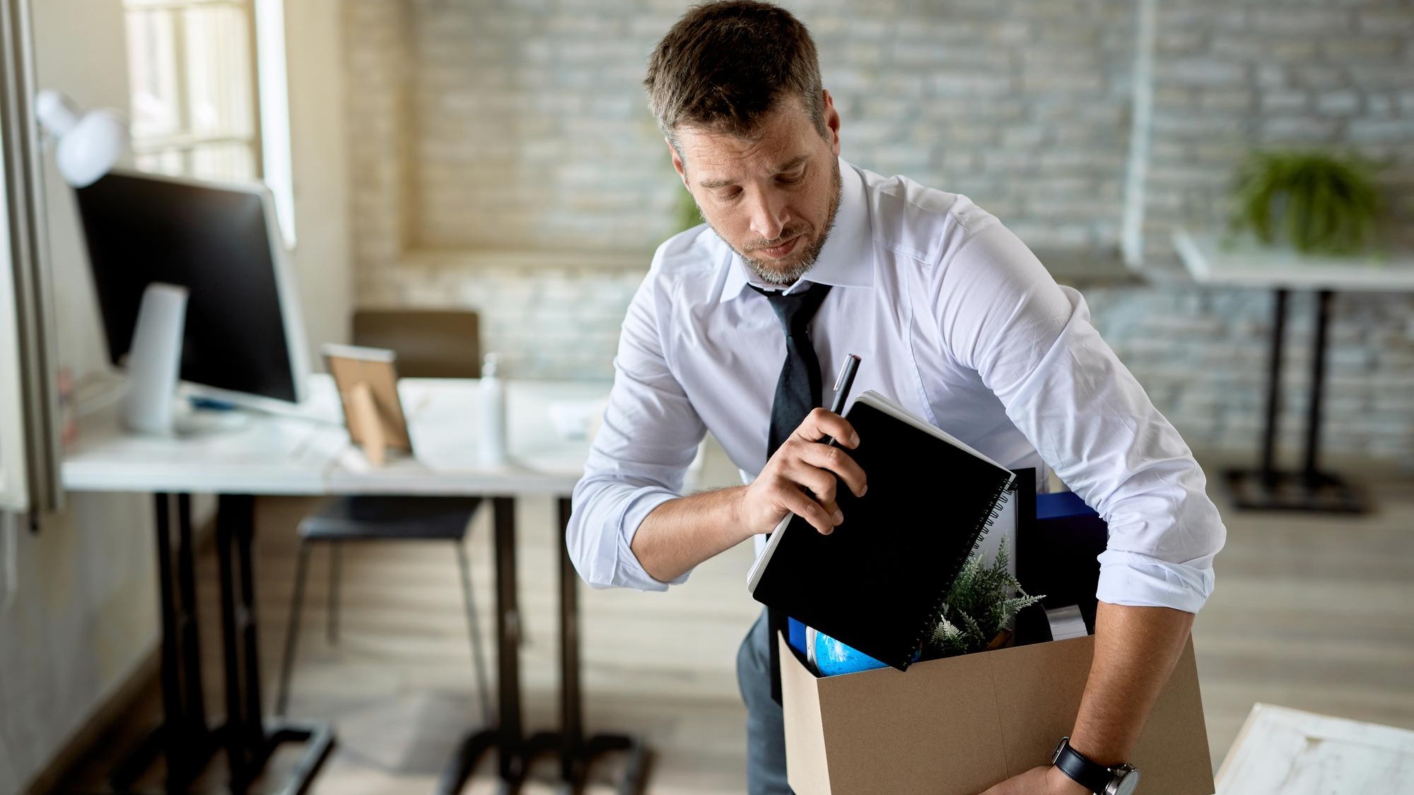 Mid adult businessman getting fired and packing his stuff in the office