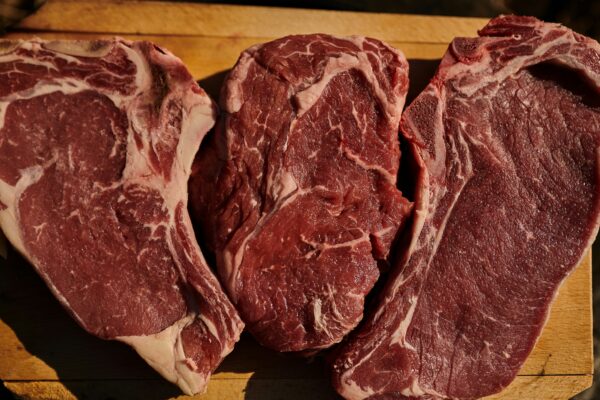 two pieces of steak on a cutting board