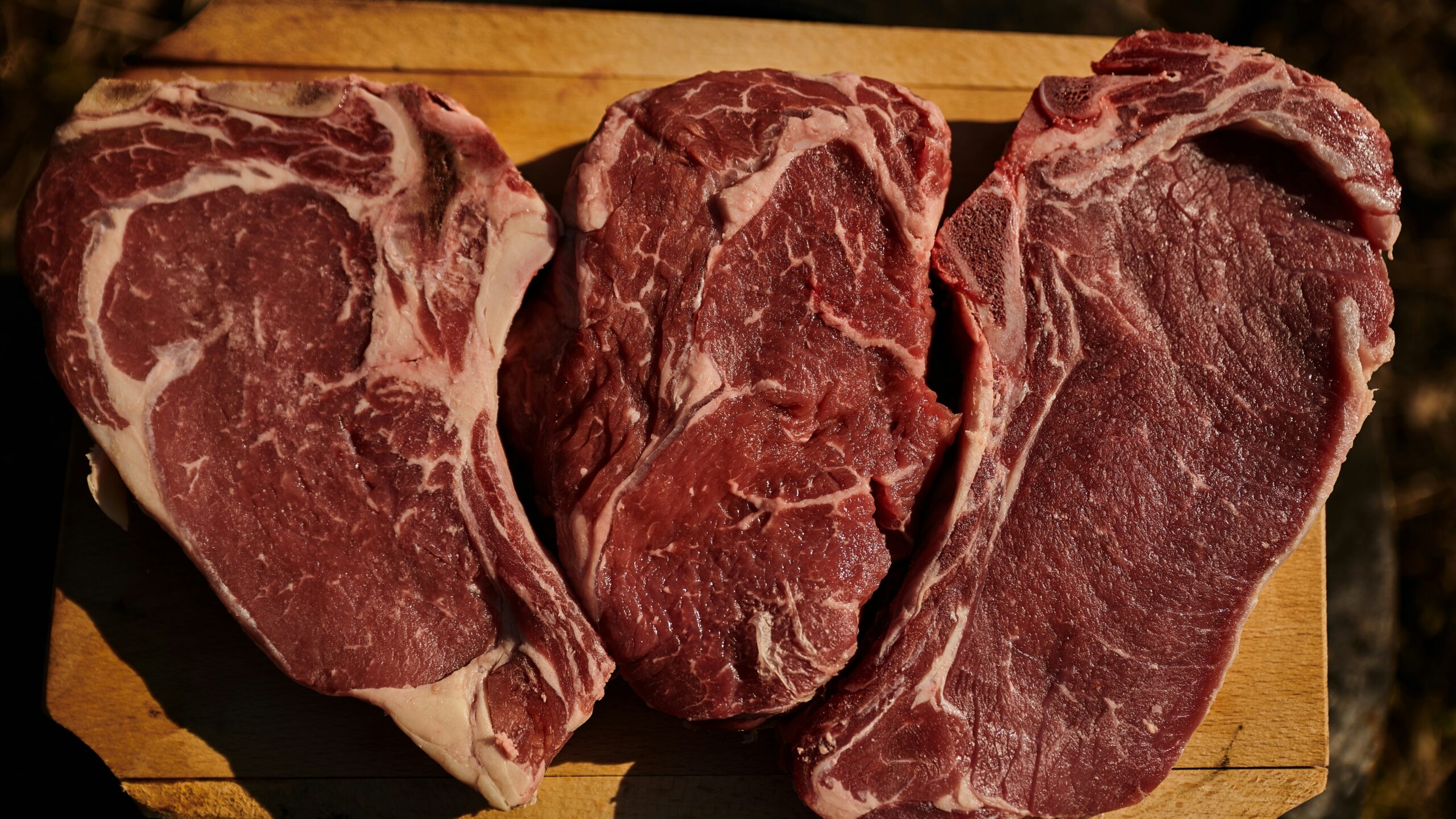 two pieces of steak on a cutting board