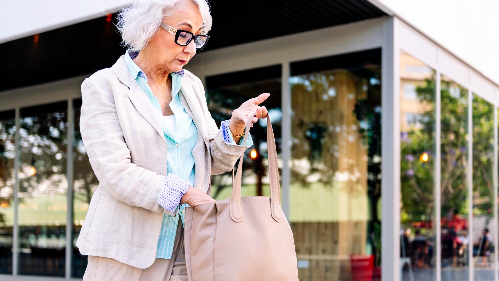 stylish mature woman looking in her bag