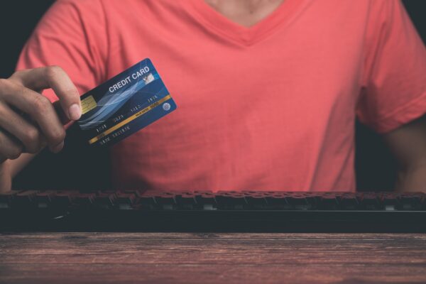 A man is using a credit card Through computer
