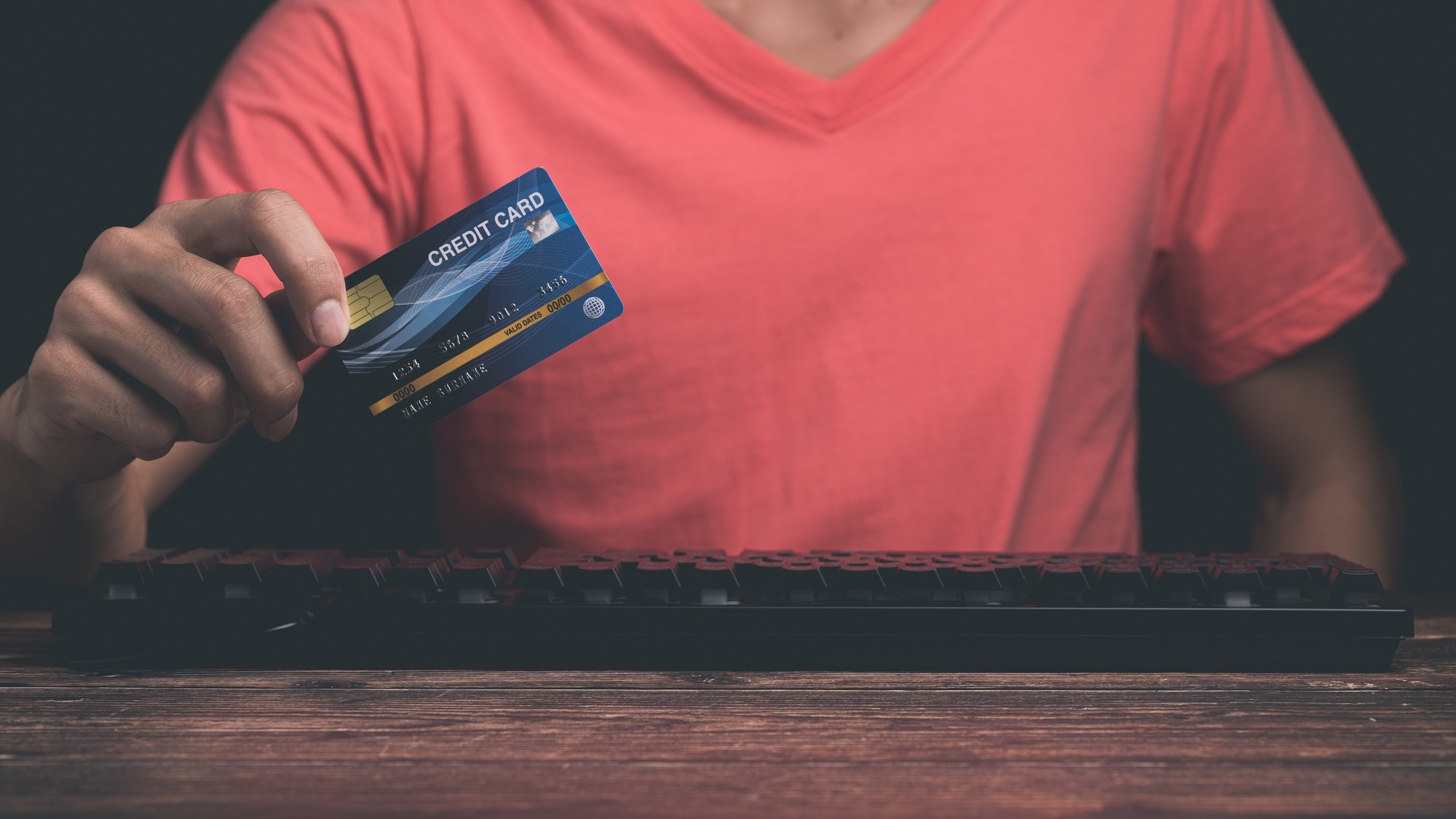 A man is using a credit card Through computer