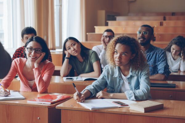 Students attentively listening in a lecture hall.