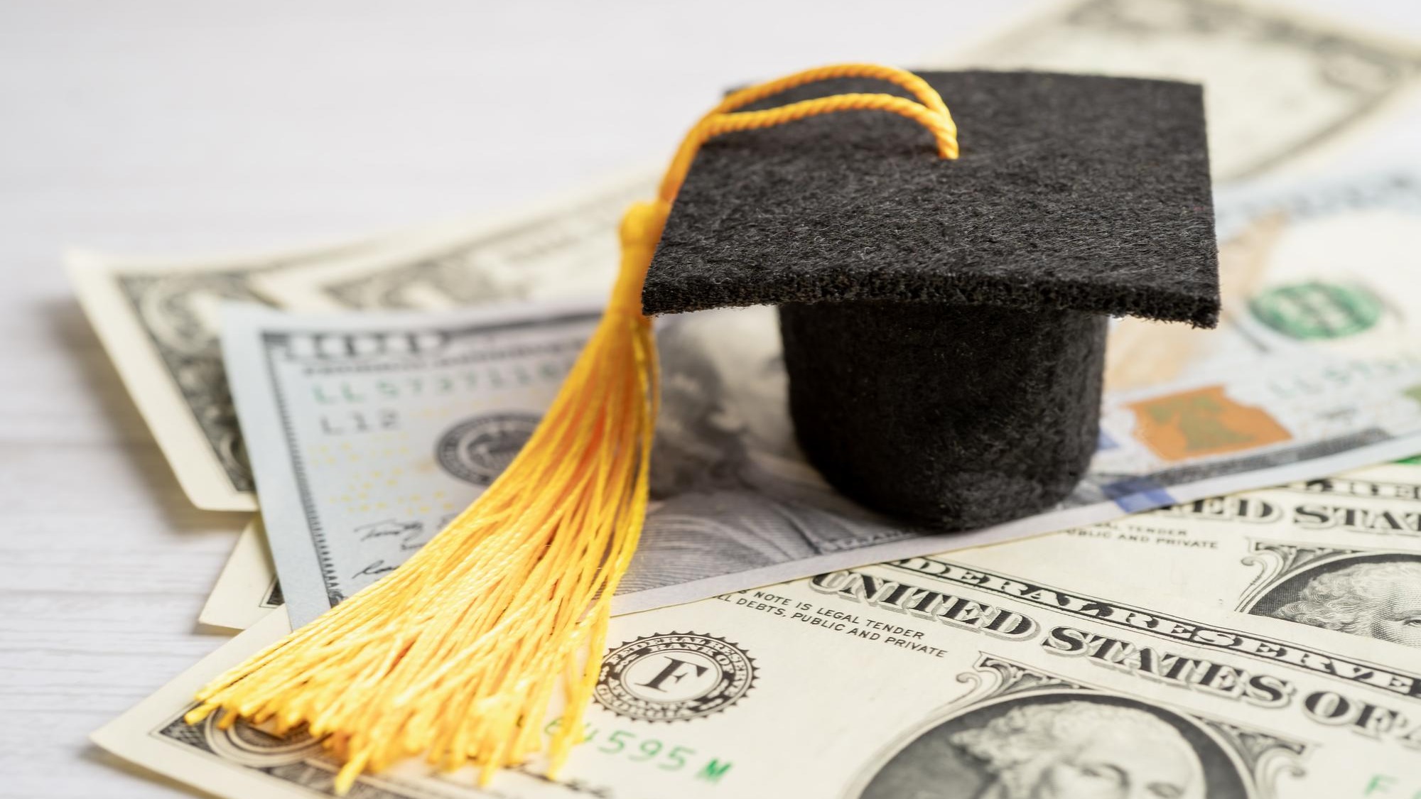 Graduation gap hat on US dollar banknotes money Education study fee learning teach concept