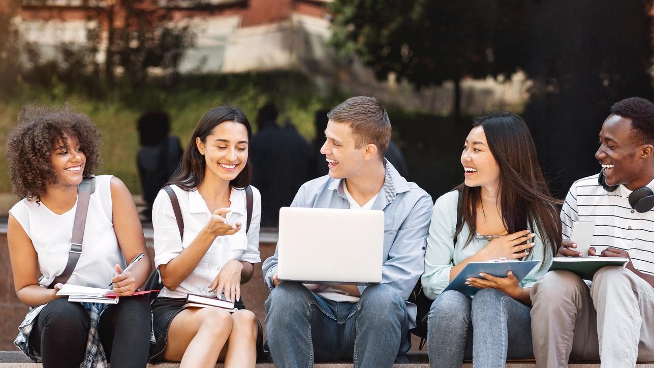 Campus Life Cheerful college students resting outdoors between classes