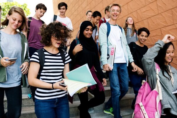 Group of school friends walking down staircase