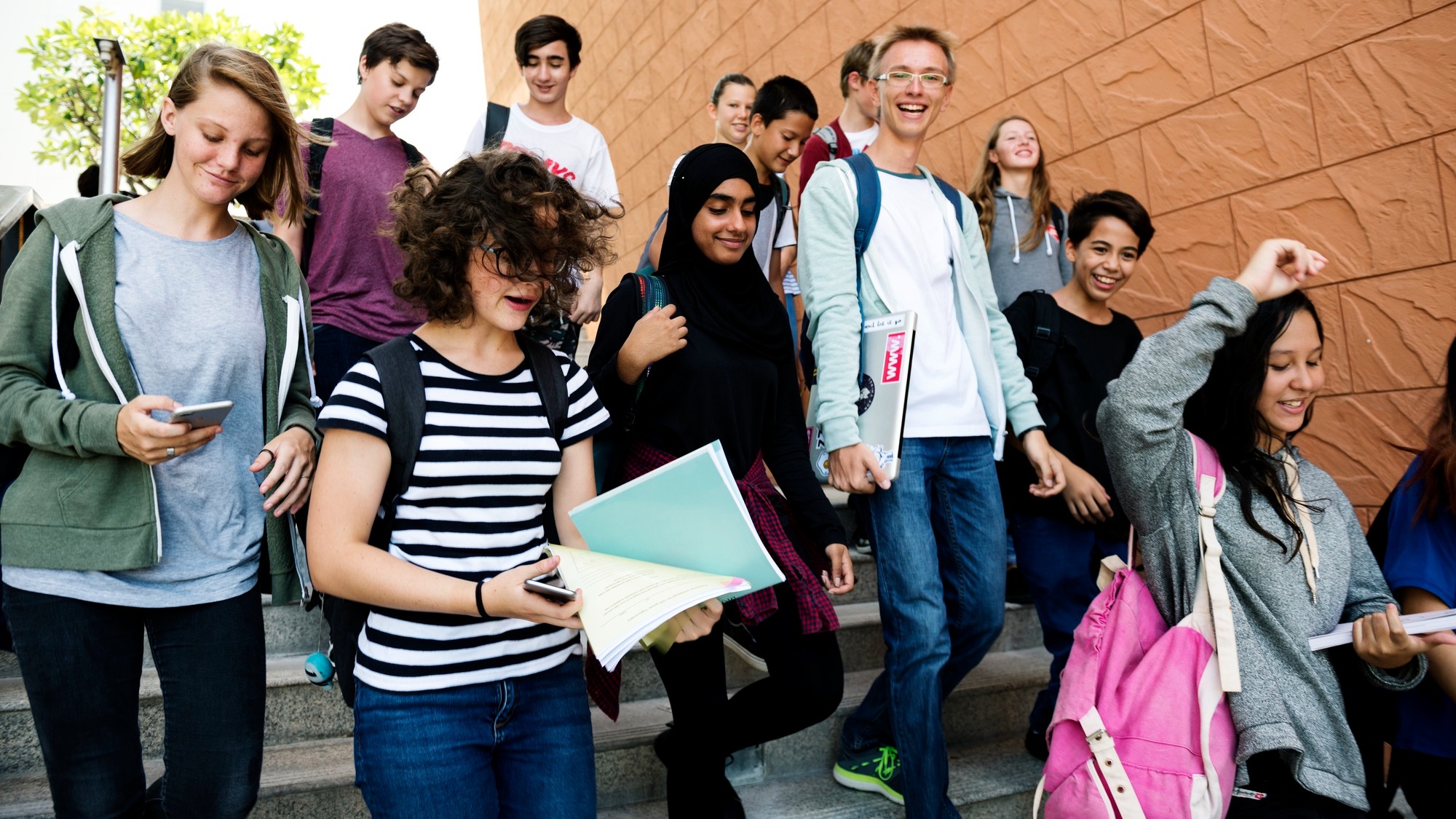 Group of school friends walking down staircase