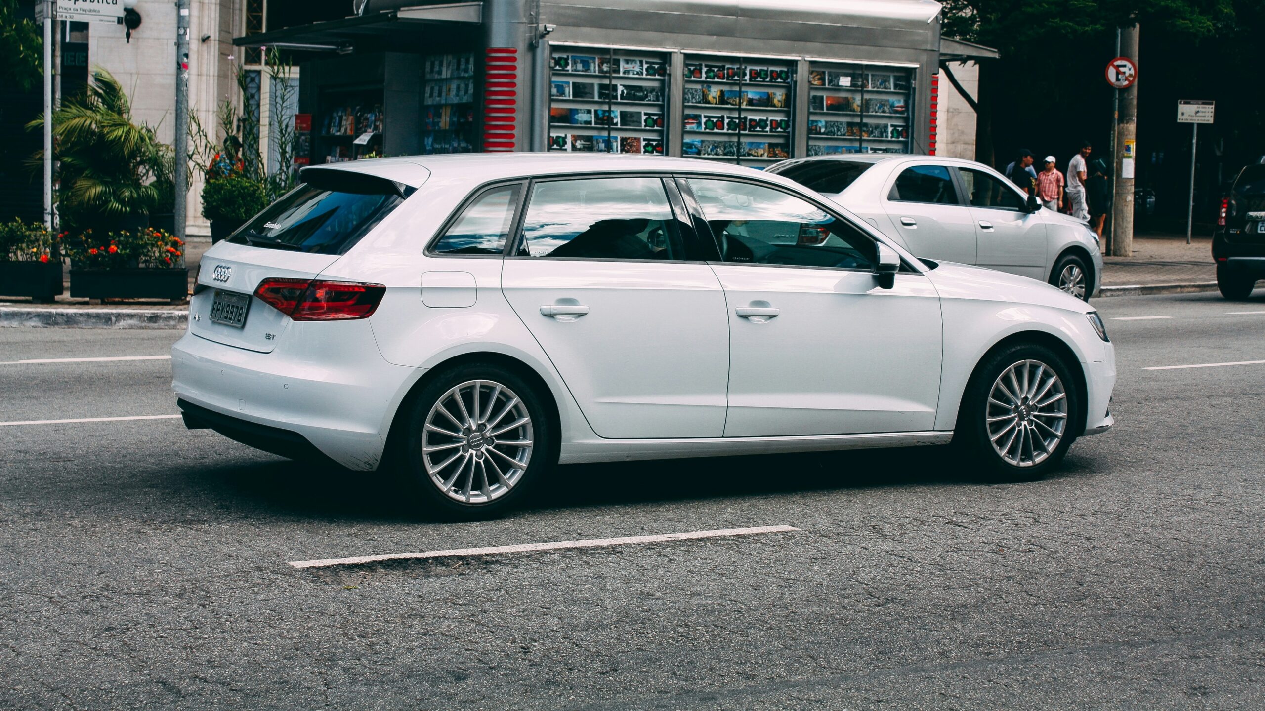 white sedan parked near white building during daytime