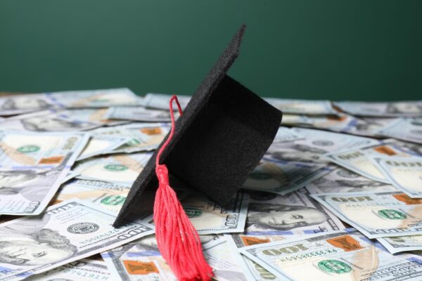 Graduate hat on dollar banknotes closeup Tuition payment
