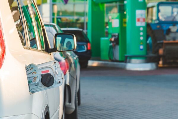 car with money in tank gas station on background copy space