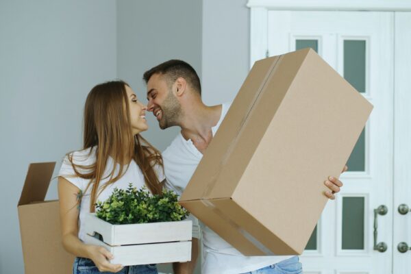 Couple holding boxes, ready to move