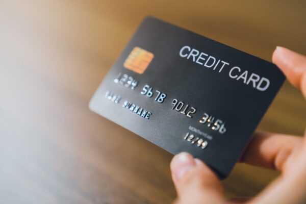 Hand holding credit card on wood table