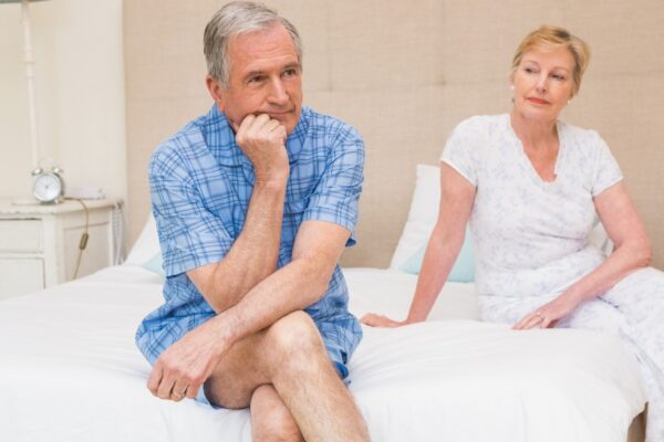 Senior couple not speaking after an argument on bed