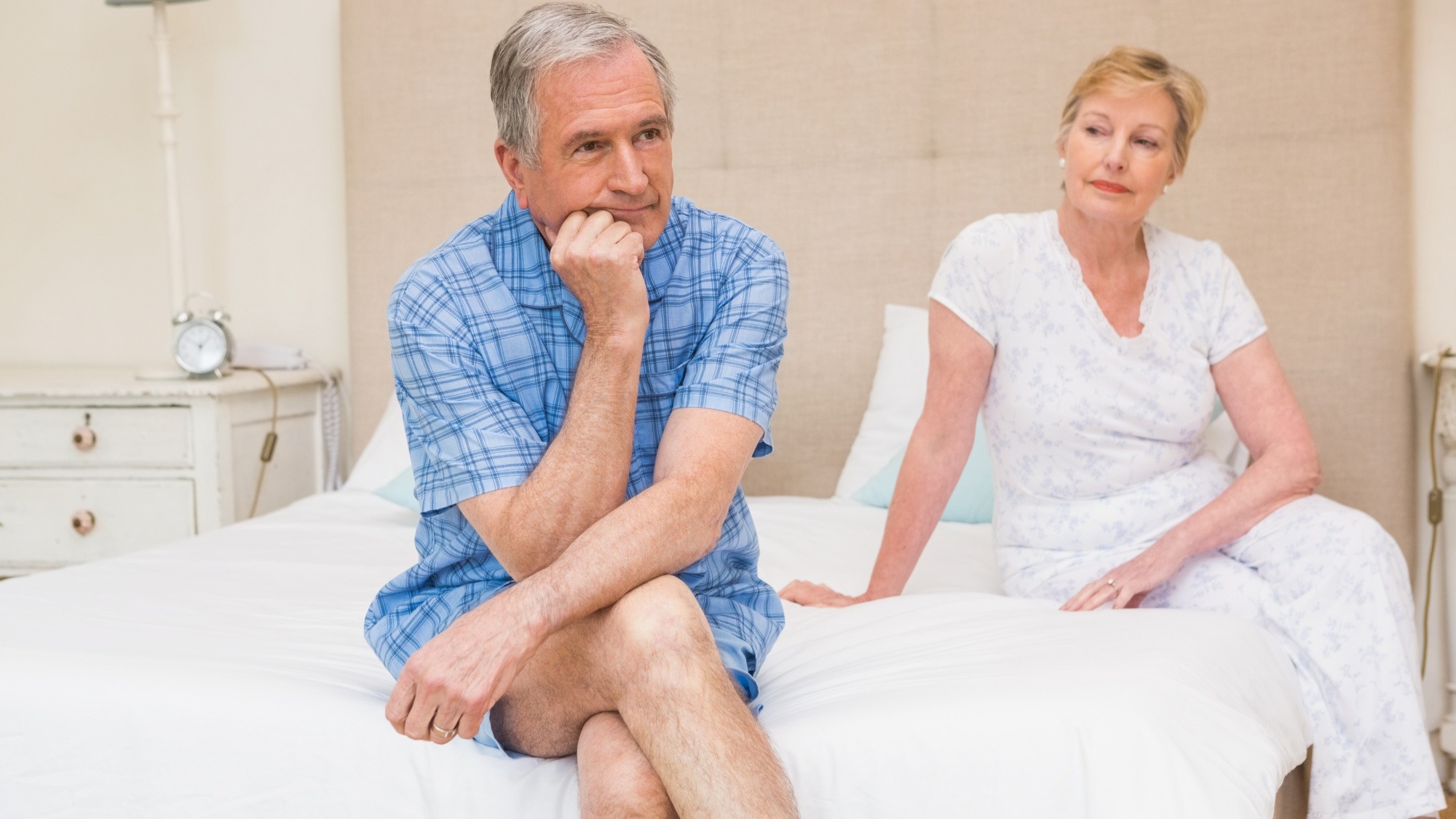 Senior couple not speaking after an argument on bed