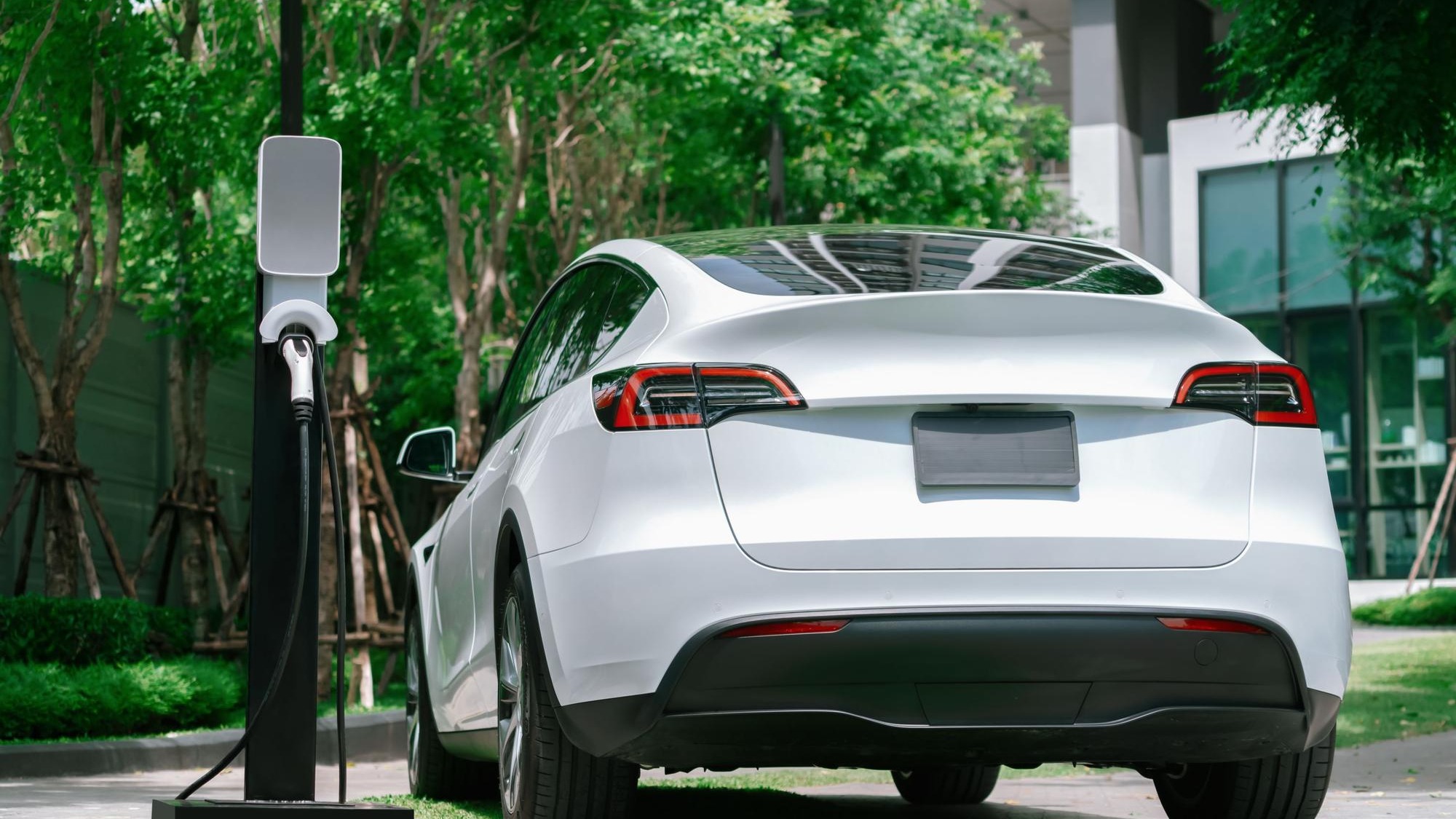 EV electric car charging in green sustainable city outdoor garden in summer Urban sustainability lifestyle by green clean rechargeable energy of electric BEV vehicle innards