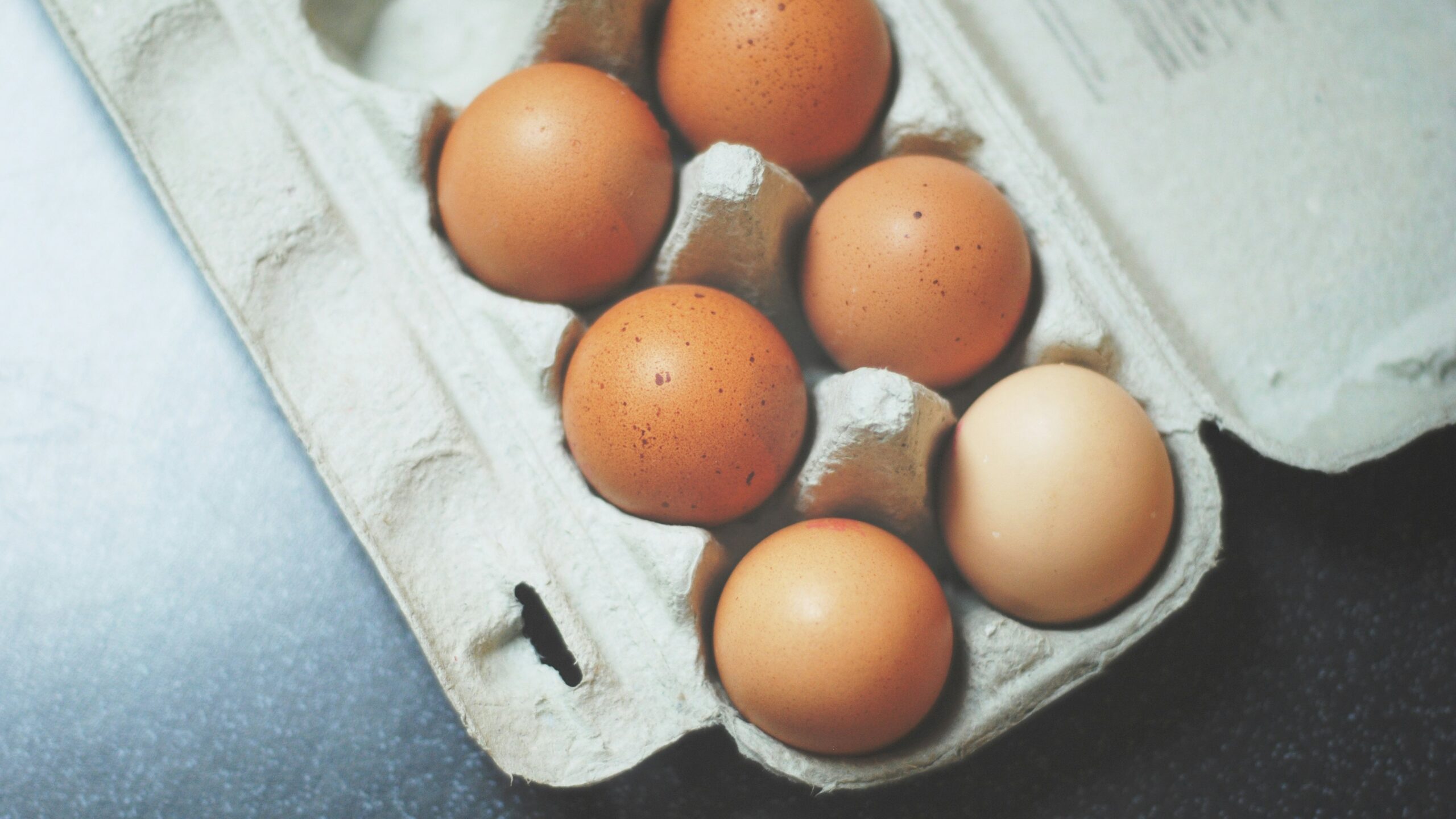 seven brown eggs on tray