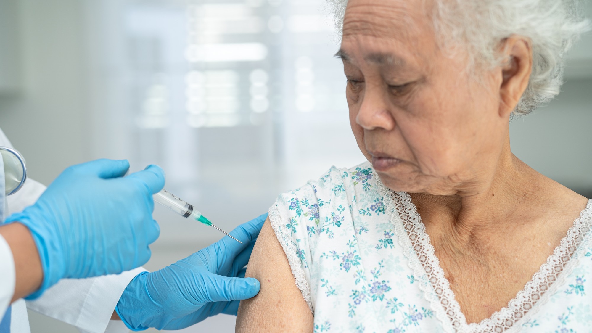 Elderly Asian senior woman getting covid19 or coronavirus vaccine by doctor